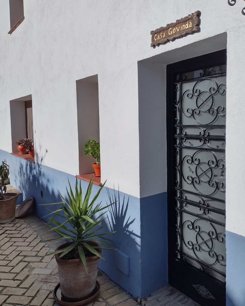 A converted farm building painted white and blue is now accommodation at Suryalila  yoga hotel